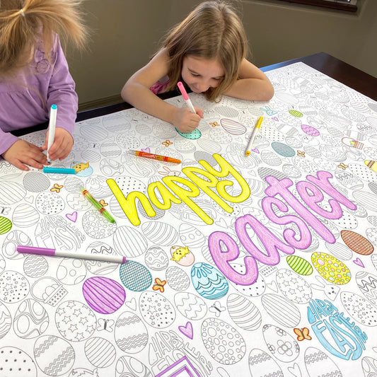 The Happy Easter giant coloring sheet being colored in with markers at a table