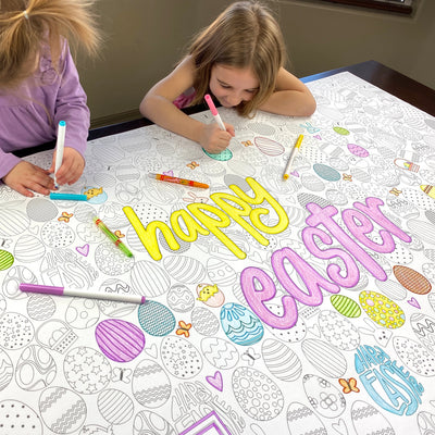 The Happy Easter giant coloring sheet being colored in with markers at a table