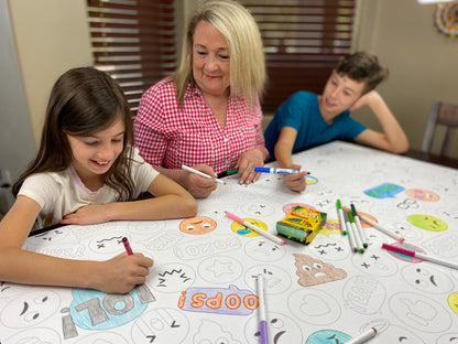 The Emoji giant coloring sheet being colored in with markers at a table