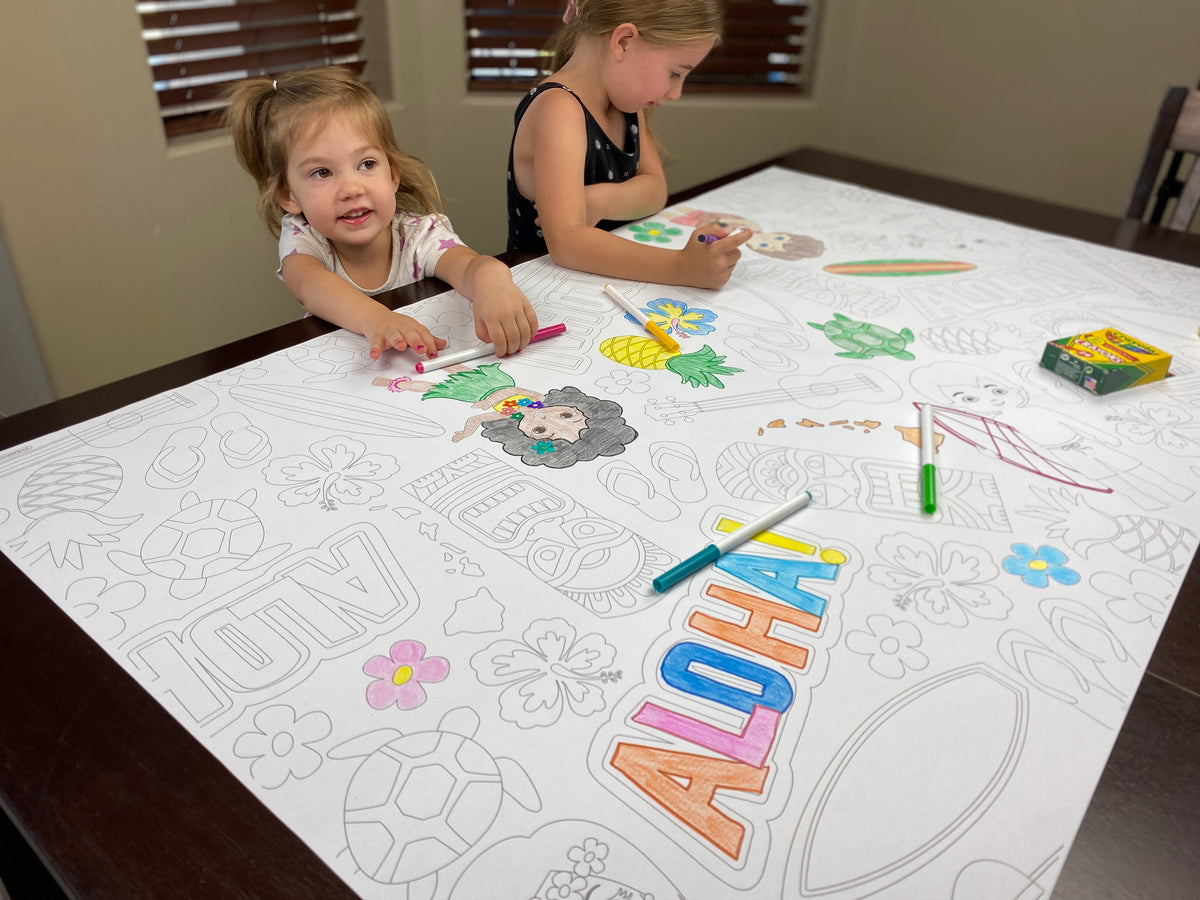 The Aloha giant coloring sheet being colored in with markers at a table