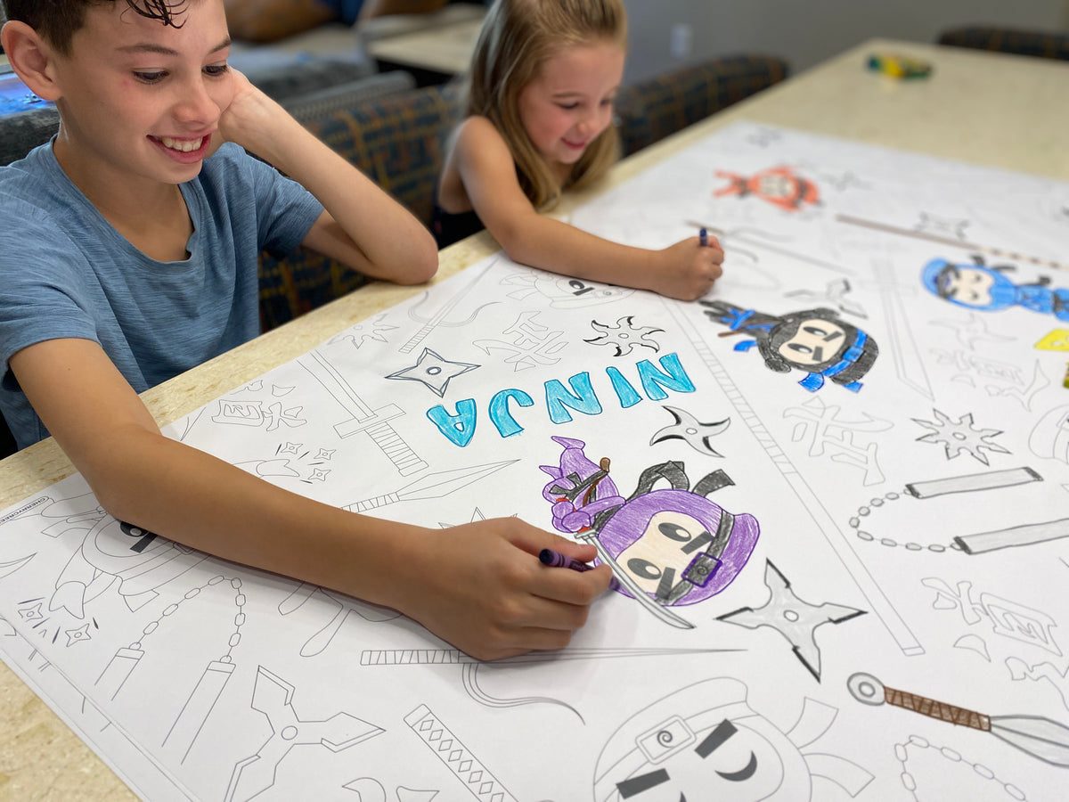 The Ninja Warrior giant coloring sheet being colored in with markers at a table