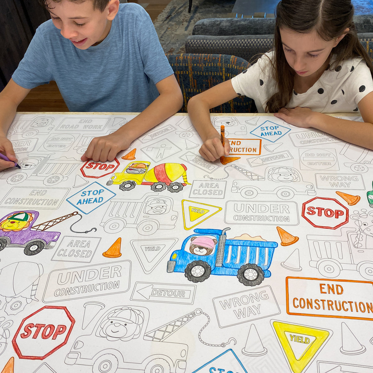 The Construction giant coloring sheet being colored in with markers at a table