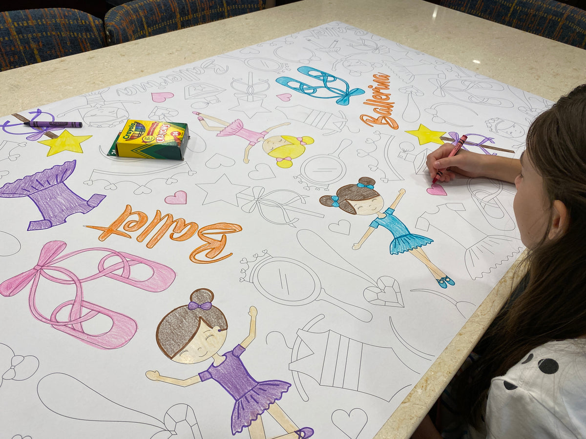 The Ballet giant coloring sheet being colored in with markers at a table