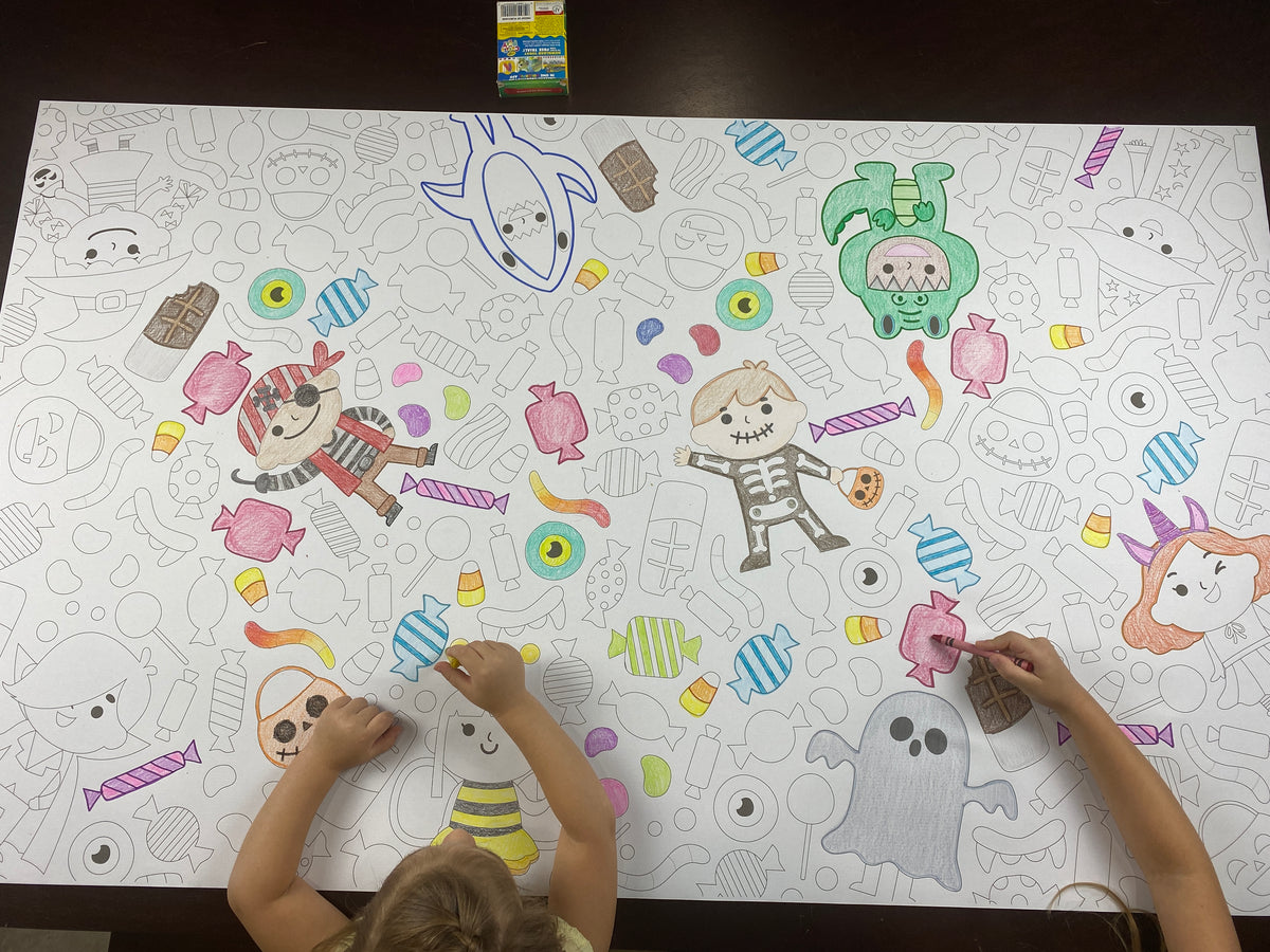 The Halloween Costume giant coloring sheet being colored in with markers at a table