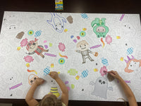 Thumbnail for The Halloween Costume giant coloring sheet being colored in with markers at a table