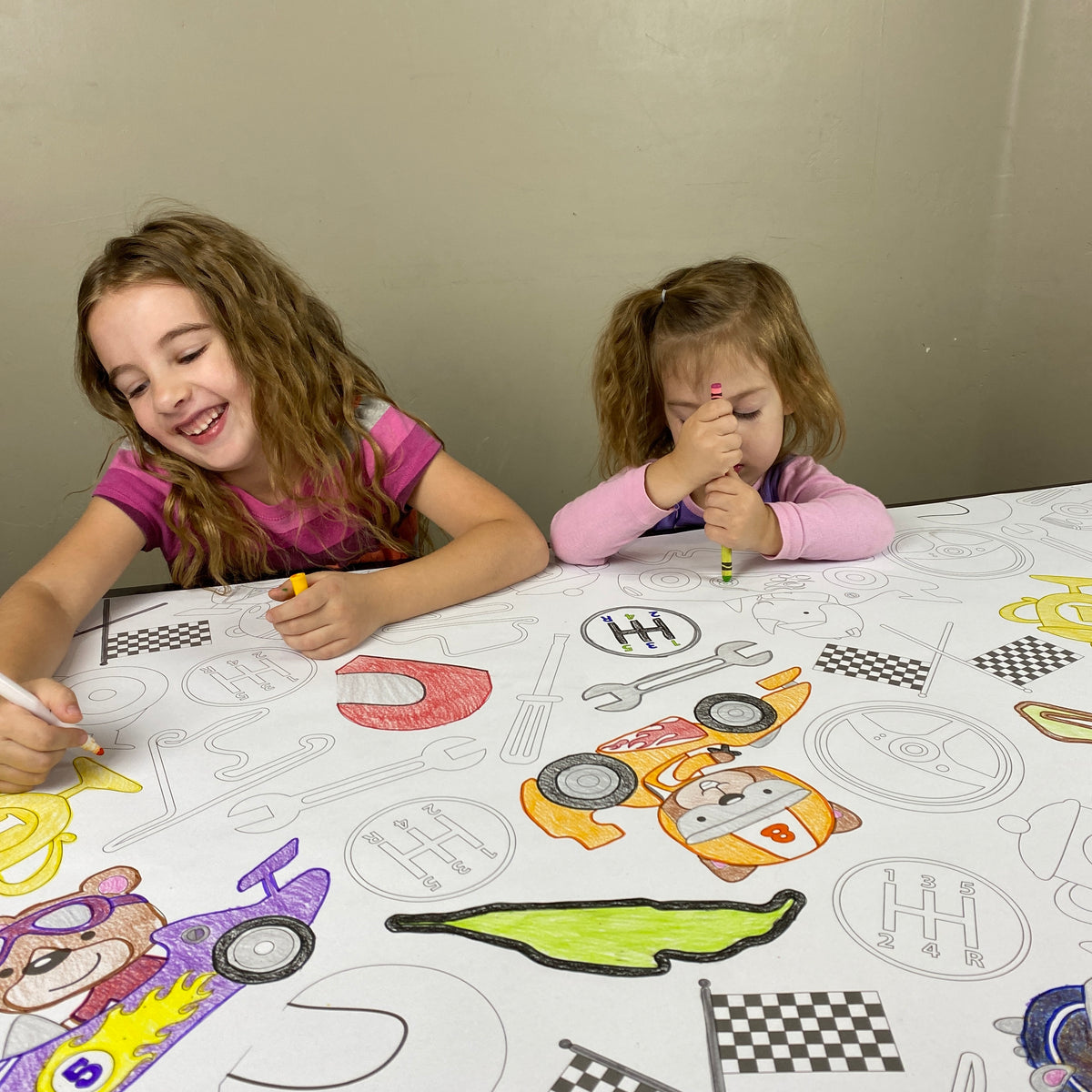 The Race Car giant coloring sheet being colored in with markers at a table