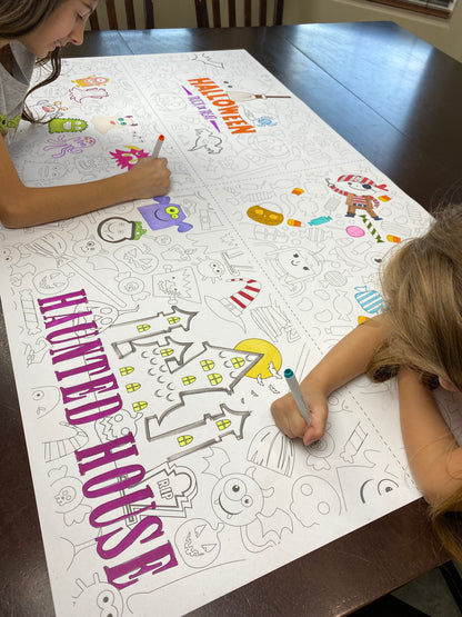 The Halloween 4-up giant coloring sheet being colored in with markers at a table