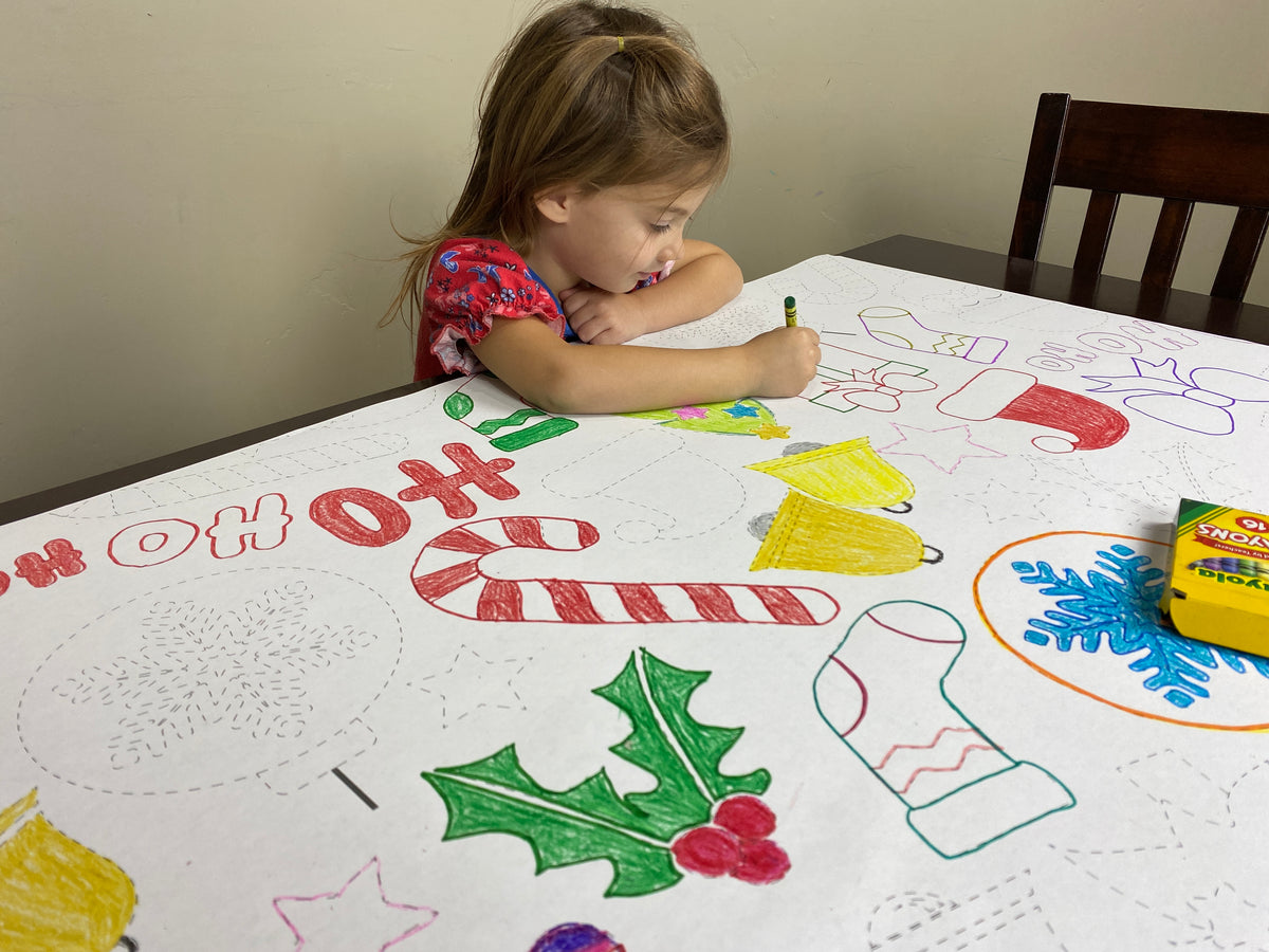 The Santa Trace and Color giant coloring sheet being colored in with markers at a table