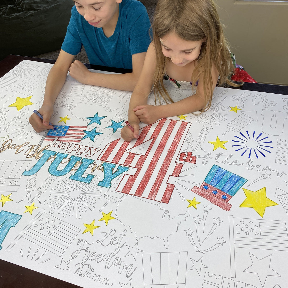 The 4th of July giant coloring sheet being colored in with markers at a table