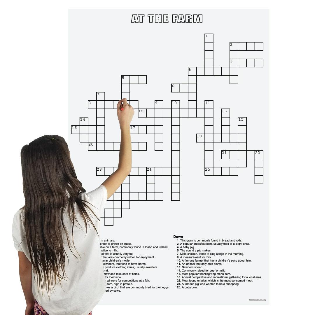 Child filling in the At The Farm giant crossword puzzle hung on a wall