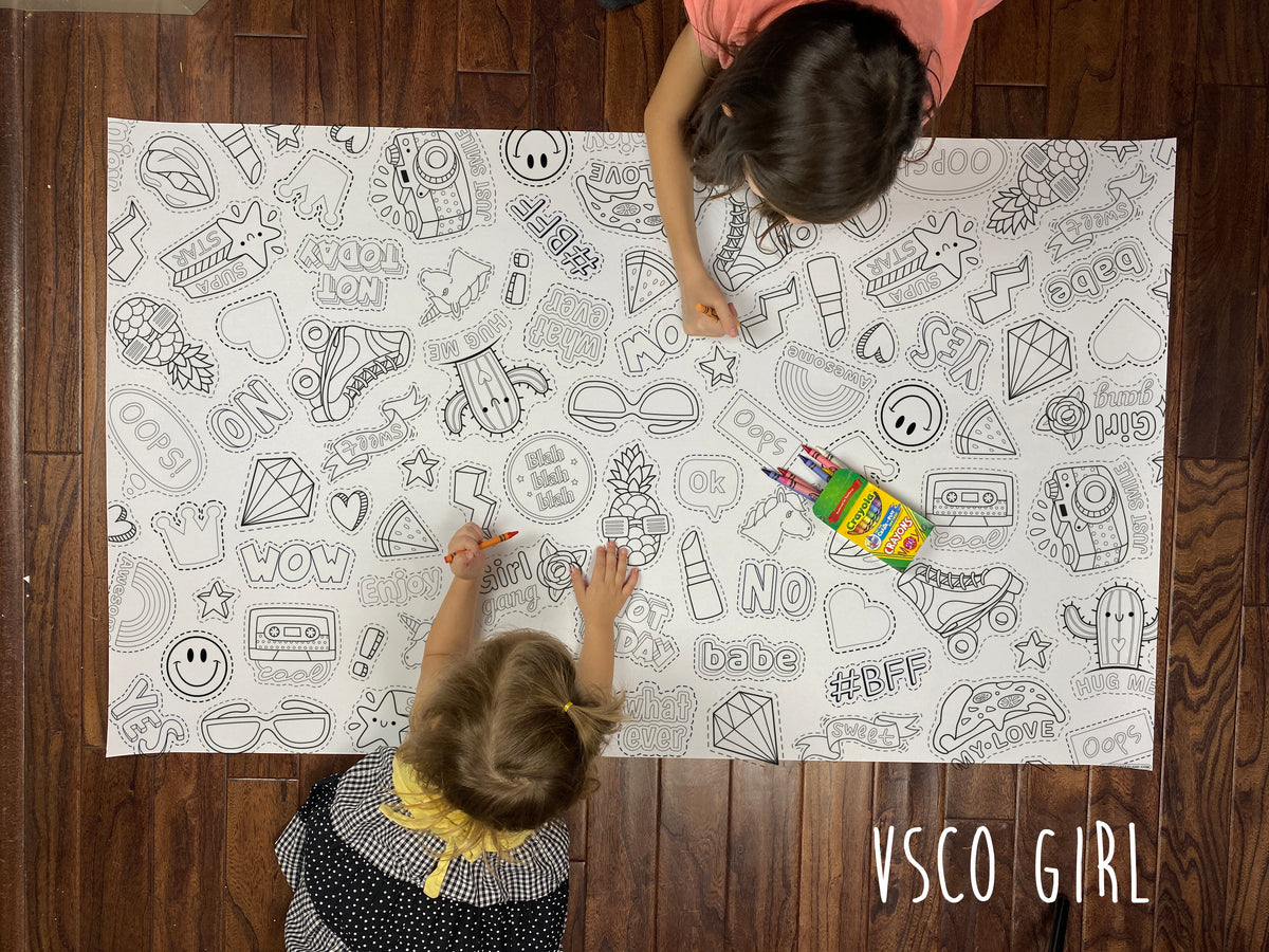 Child coloring a teen trend themed giant coloring sheet on a wood floor with crayons