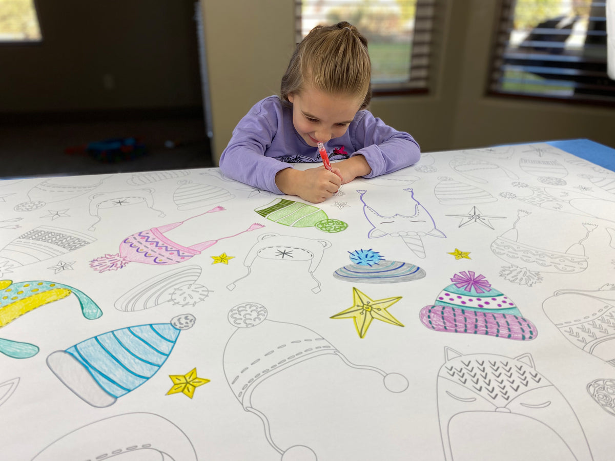 The Winter Hats giant coloring sheet being colored in with markers at a table