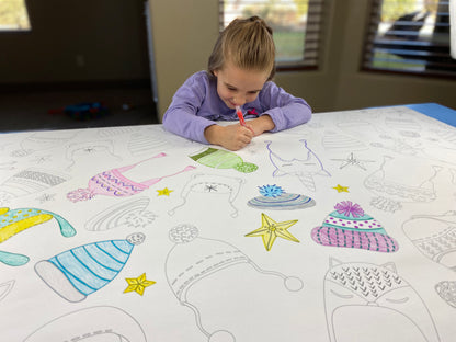 The Winter Hats giant coloring sheet being colored in with markers at a table