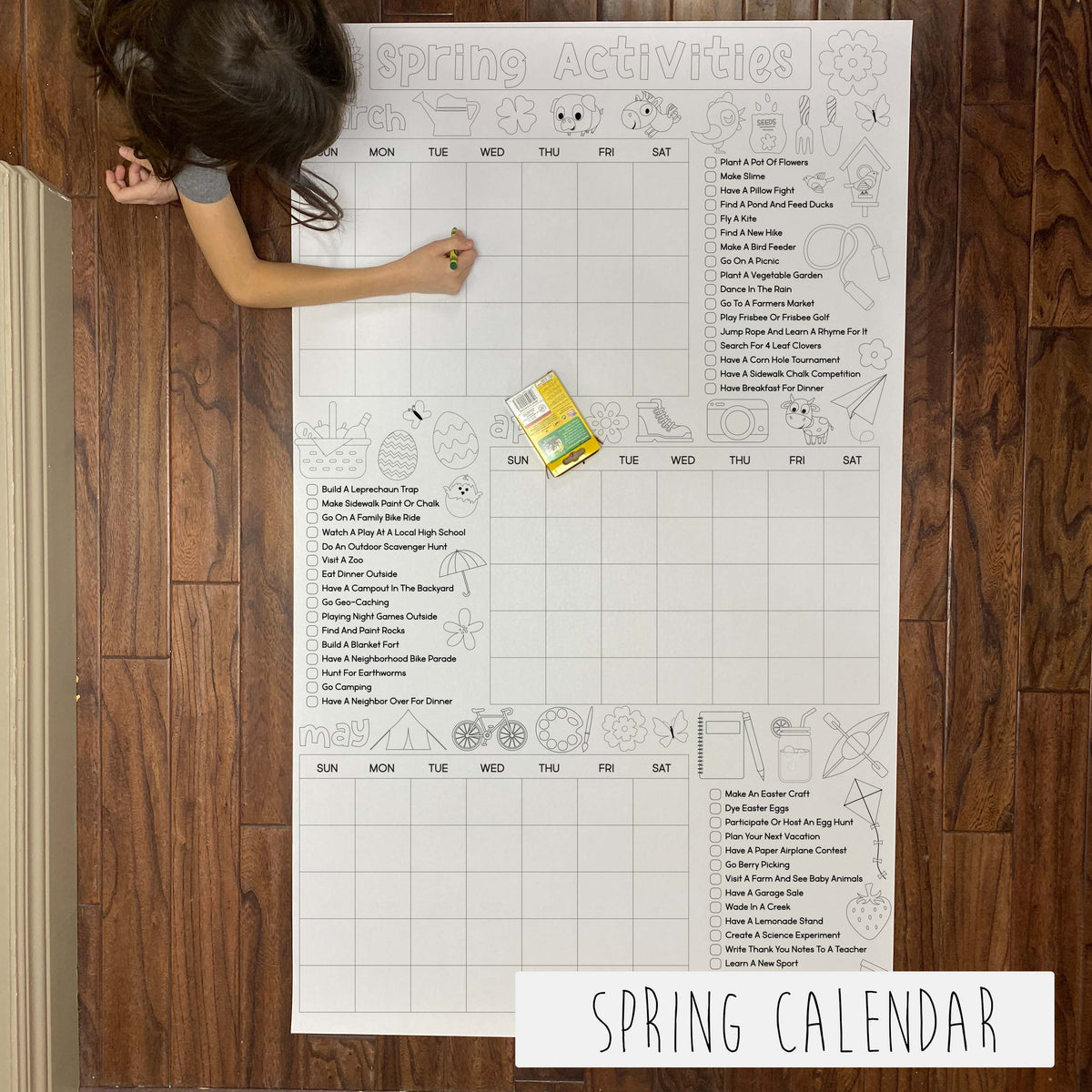 Child coloring the Spring Activity Calendar giant coloring sheet on a wood floor