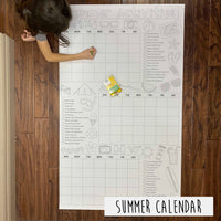 Thumbnail for Child coloring the Summer Activity Calendar giant coloring sheet on a wood floor