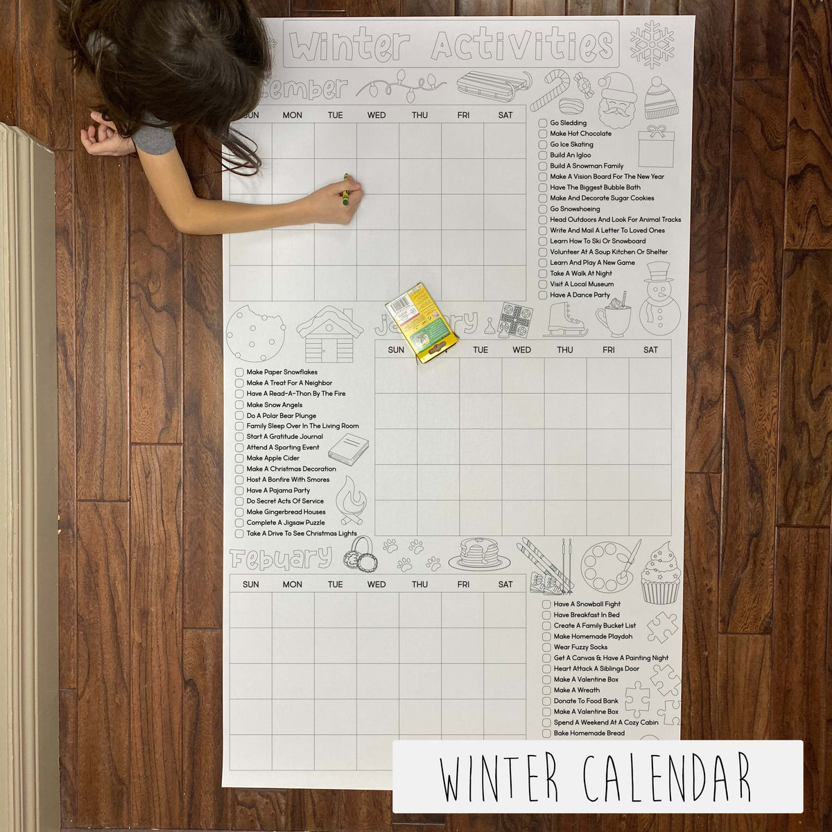 A large printable coloring banner titled 'WINTER CALENDAR' laid out on the floor with a child coloring on it, with various winter activities listed for each day.