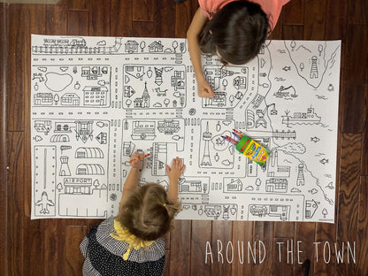 Child coloring the Around The Town giant coloring sheet on a wood floor with crayons