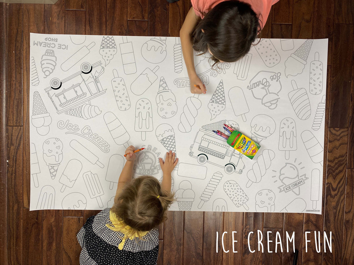 Child coloring the Ice Cream Fun giant coloring sheet on a wood floor with crayons