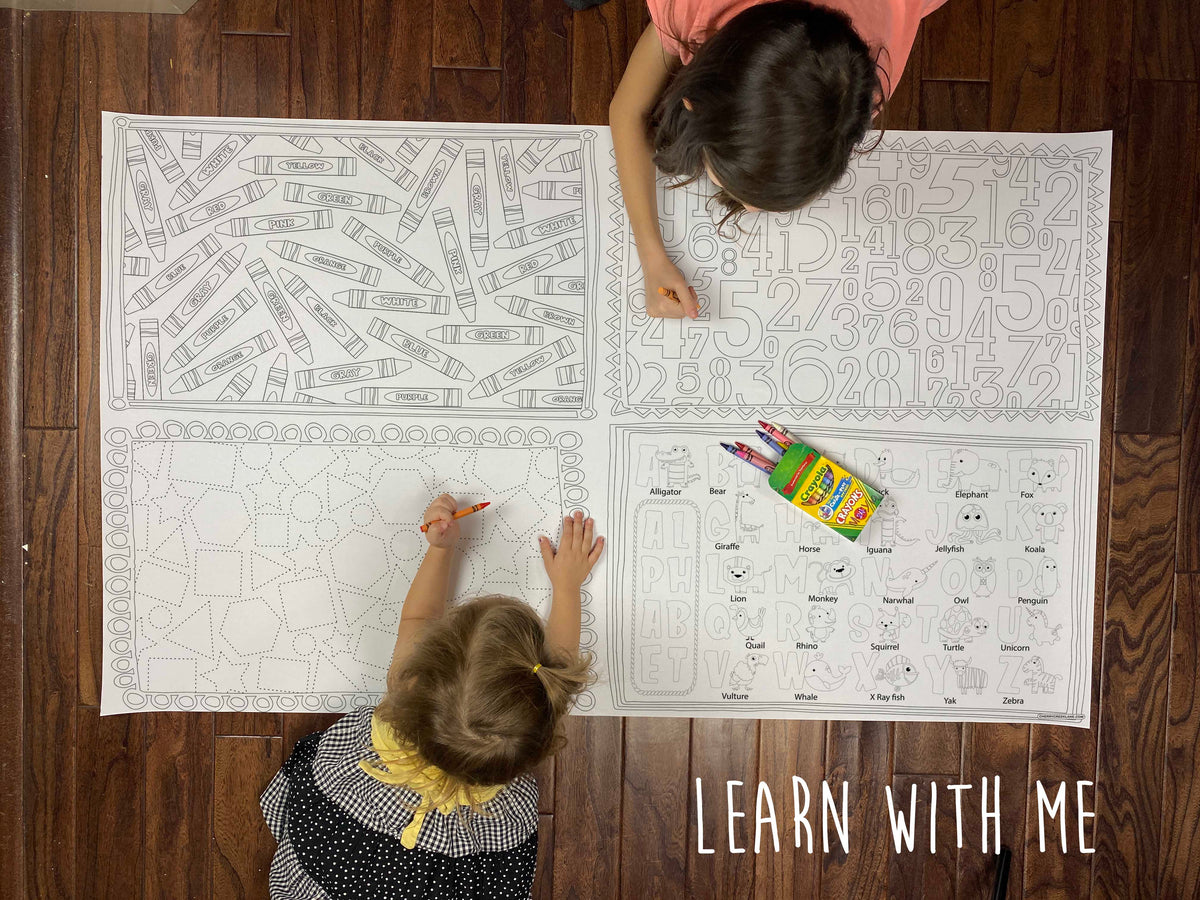 Child coloring the Learn With Me giant coloring sheet on a wood floor with crayons