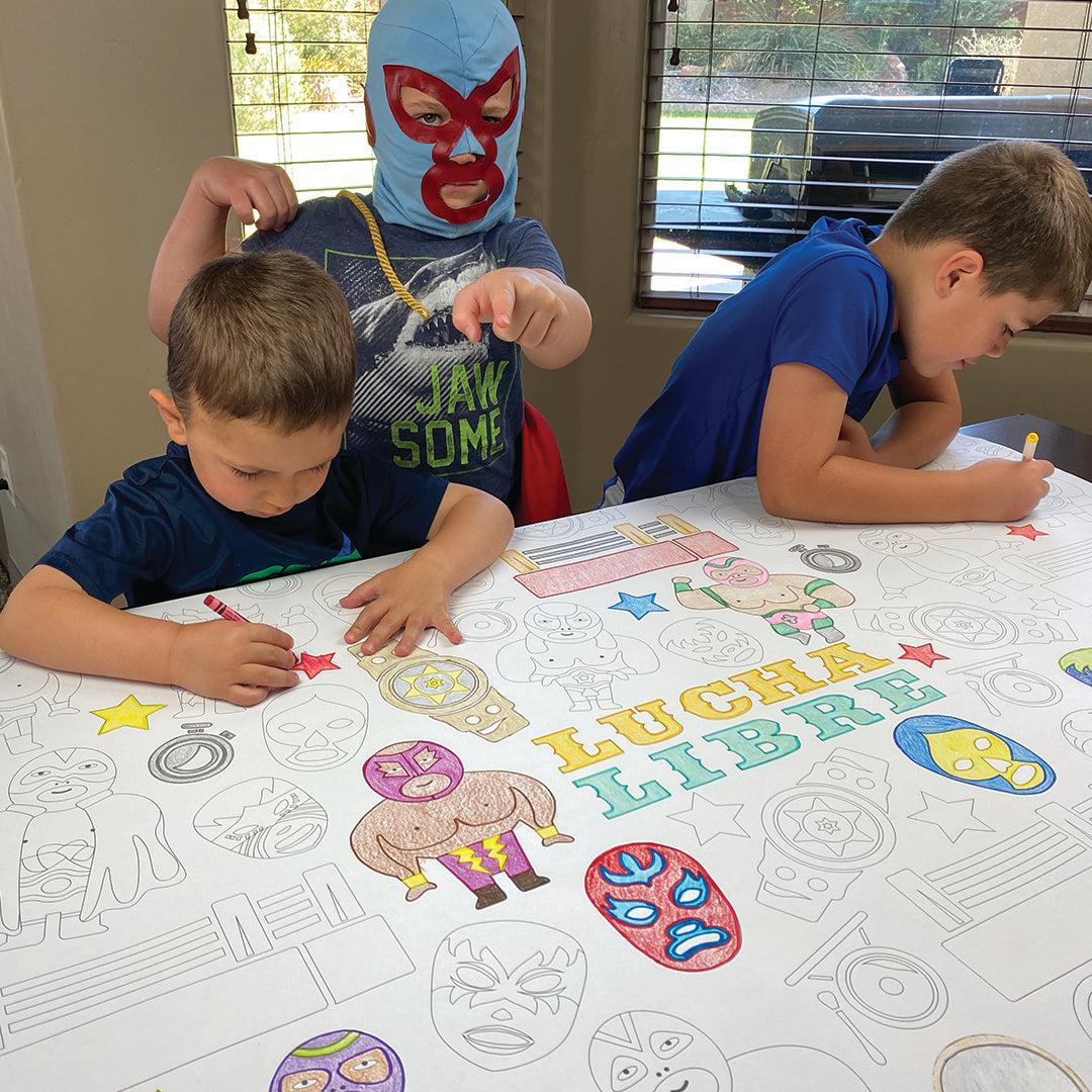The Lucha Libre giant coloring sheet being colored in with markers at a table