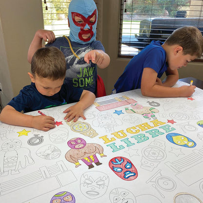 The Lucha Libre giant coloring sheet being colored in with markers at a table