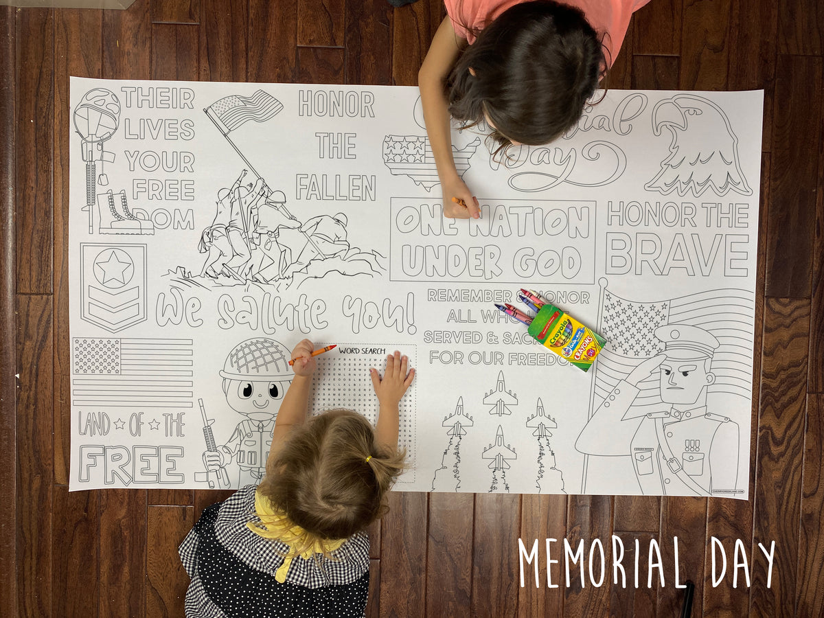 Child coloring the Memorial Day giant coloring sheet on a wood floor with crayons
