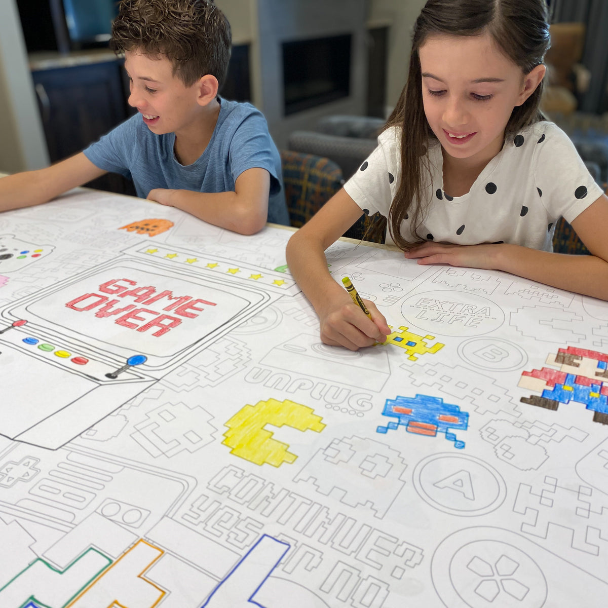 The Video Game giant coloring sheet being colored in with markers at a table